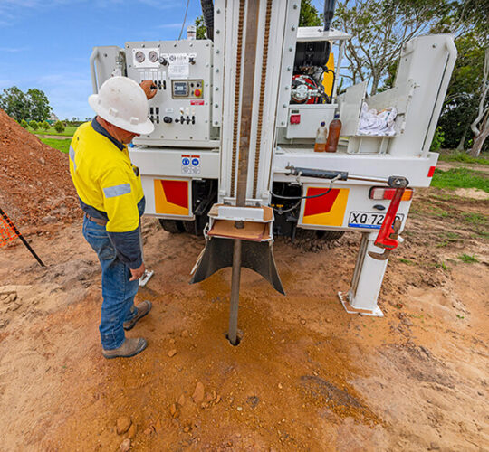 A member of the Trans Earthing team working the drill rig making sure it is running properly