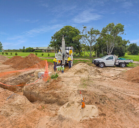 Two members of the Trans Earthing team working the drill rig